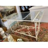 A wrought iron glass top coffee table