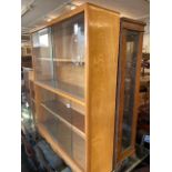 A retro bookcase with sliding doors and a side table