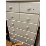A white chest of four drawers