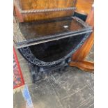 A black lacquered drop flap table