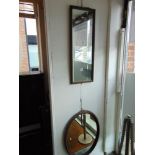 An oval wall mirror and a rectangular wall mirror