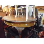 An Oval mahogany extending table on ball and claw feet
