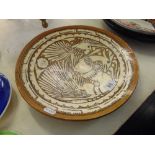 An Arts and Crafts style pottery charger a.