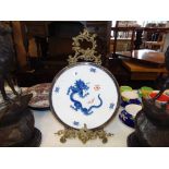 A Meissen plate with dragon design on a metal stand