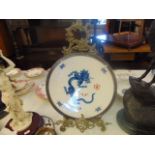 A Meissen plate with dragon design on a metal stand