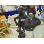 A bronze figure of a boy carrying a basket