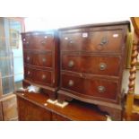 A small pair of serpentine mahogany three drawer chests