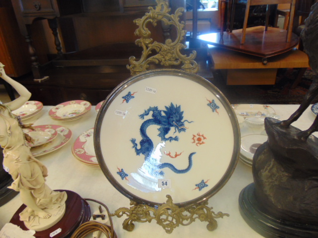 A Meissen plate with dragon design on a metal stand