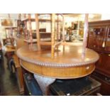 An Oval mahogany extending table on ball and claw feet