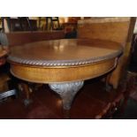 An Oval mahogany extending table on ball and claw feet