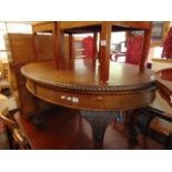 An Oval mahogany extending table on ball and claw feet