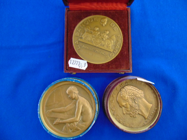 Three assorted bronze medals; Artdeco Nude lady making tapestry by P.