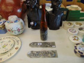 A glass bottle with metal base and two Art Nouveau door plaques