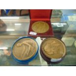 Three assorted bronze medals; Artdeco Nude lady making tapestry by P.