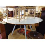 A white circular table with metal pedestal legs,
