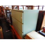 A green three drawer chest,