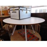 A white circular table with metal pedestal legs,