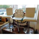 Three white and chrome bar stools