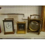 A brass carriage clock and two mantle clocks