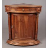 A Victorian oak bow fronted, free standing corner cupboard, with hinged top drawer and turned