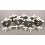 A box of seven blackboard restaurant table numbers. Comprising of a heart on an easel.