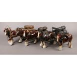 Four ceramic shire horses; three pulling barrel carts.