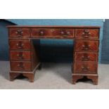 A mahogany writing desk with brown leather and gilt insert writing surface. Comprising of nine
