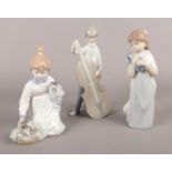 Three Lladro/Nao figurines. girl with kittens, boy with cello etc damage to top of cello on