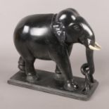 A marble elephant, holding a branch, raised on stepped plinth. 25cm high. Some damage to the tusks