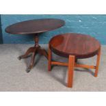 A small mahogany oval table, raised on brass clawed feet and casters, alongside a round occasional