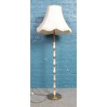 A brass and onyx standard lamp with frilled cream shade. In working order.