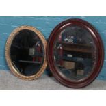 A mahogany framed oval bevel edged wall mirror along with an ornate gilt framed example.