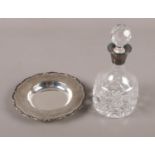 A silver trinket dish along with a silver collared cut glass scent bottle.