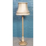 A turned and reeded standard lamp on circular base.
