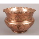 A copper arts & crafts planter with hammered and engraved decoration.