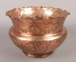 A copper arts & crafts planter with hammered and engraved decoration.
