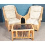 A four piece rattan conservatory suite. Comprising of two seat sofa, two armchairs and glass top