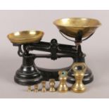 A set of weighing scales with brass bowls and weights (¼oz-1lb).