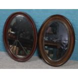 Two mahogany bevel edged oval framed wall mirrors. (67cm x 40cm)