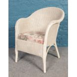 A Lloyd Loom Lusty white chair with floral seat cushion. H: 74cm, W:51.5cm, D: 43cm.