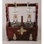 A double decanter tantalus, complete with key. 33cm high.