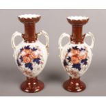 A pair of late Victorian/early Edwardian Crown Derby twin handled urns. Produced by Holmes and