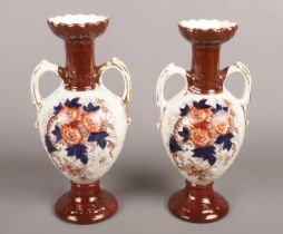 A pair of late Victorian/early Edwardian Crown Derby twin handled urns. Produced by Holmes and