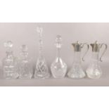 Four cut glass decanters & two silver plated claret jugs.