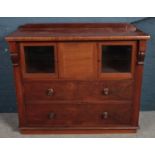 A Victorian carved mahogany side cabinet. With two glass panel doors and fold over centre door. (