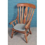 A mahogany slatback armchair with turned legs.