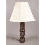A hardwood table lamp with cream shade, depicted as a Tribal figure head. In working order.