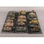 A box of diecast military armoured vehicles raised on plinths. Including AMC Schneider P16,