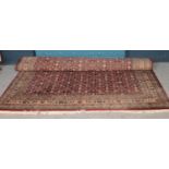 A large Eastern red ground wool rug, all over pattern decoration. (300cm x 240cm)