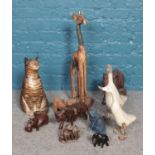 A box of ornamental animals. Including wooden giraffe, elephant figure group, plaster cast cat, etc.